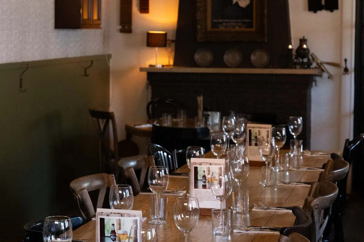 Een lange gedekte tafel bij de open haard en de kroonluchters van De Rosier