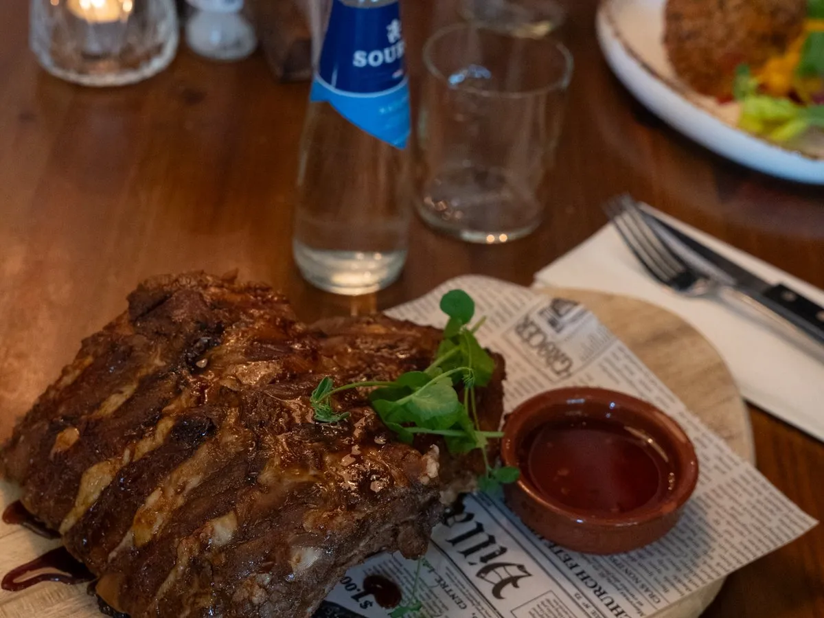 Vlaamse ribkes met kruiden en dipsaus op een houten plank